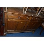 AN OAK PANELLED SIDEBOARD, with two drawers, approximate size width 125cm x height 90cm x depth 47cm