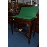 AN EDWARDIAN MAHOGANY FOLD OVER CARD TABLE, on square tapering legs united by a crossed stretcher