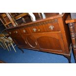 A MAHOGANY SIDEBOARD, with three drawers over two cupboard doors and a shaped back