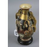 A JAPANESE SATSUMA WARE TWIN HANDLED VASE, decorated with figures of immortals amongst raised