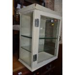 A PAINTED METAL VINTAGE MEDICAL CABINET, glazed on two sides and door with three glass shelves