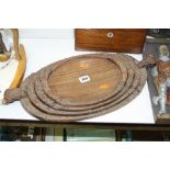 A SET OF FOUR CARVED OVAL HARDWOOD TRAYS, smallest oval length 27.5cm, the largest with handles