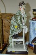 A FLORENCE GIUSEPPE ARMANI FIGURE, Clown on a chair, height approximately 46cm