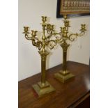 A PAIR OF EARLY 20TH CENTURY BRASS FIVE BRANCH CANDELABRAS, on a column stand and square base