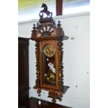 A VICTORIAN WALNUT VIENNA WALL CLOCK, the circular dial with Roman numerals below a carved jumping