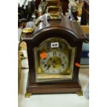 A CONTINENTAL MANTEL CLOCK, having arched brass dial with silvered chapter ring and Arabic numerals,