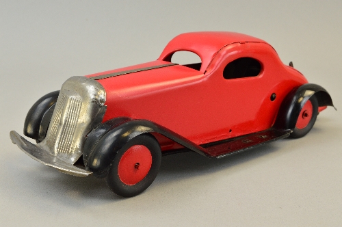 A MARX TINPLATE CLOCKWORK SALOON CAR, British made, red body and hubs, black chassis and