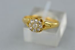 AN EARLY 20TH CENTURY DIAMOND DAISY CLUSTER RING, nine old cut diamonds, estimated total diamond