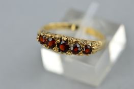 A 9CT GOLD GARNET HALF HOOP RING, ring size O, hallmarked 9ct gold, approximate gross weight 2.7