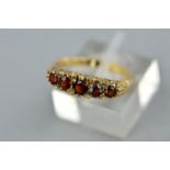 A 9CT GOLD GARNET HALF HOOP RING, ring size O, hallmarked 9ct gold, approximate gross weight 2.7