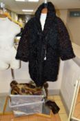 AN ASTRACAN COAT AND TWO BOXES OF VARIOUS FUR STOLES , TRIMS ETC