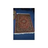 A KESHAN STYLE RUG, red, blue and gold ground, multi strap border, foliate design and central