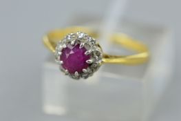 A LATE 20TH CENTURY 18CT GOLD RUBY AND DIAMOND ROUND CLUSTER RING, ruby measuring approximately 4.