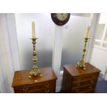 A PAIR OF BRASS CANDLE STANDS, on triple legs, approximate height 61cm