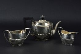 A LATE VICTORIAN MATCHED SILVER THREE PIECE BACHELOR'S TEASET, of oval reeded form, teapot with