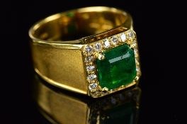 A MODERN 18CT GOLD EMERALD AND DIAMOND SQUARE SIGNET RING, centring an emerald cut emerald measuring