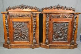 A PAIR OF VICTORIAN OAK CABINETS WITH CARVED DECORATION, the short raised backs with a cresting rail
