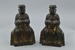A PAIR OF CHINESE LACQUERED AND GILT BRONZE FIGURES OF SEATED ELDERS, cast with hands in front,