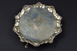 A GEORGE III CIRCULAR SILVER WAITER, raised shell and scroll rim, central cartouche with bull's head