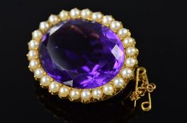 AN EARLY 20TH CENTURY LARGE OVAL AMETHYST AND SPLIT PEARL BROOCH, measuring approximately 33mm x