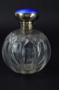 A GEORGE V SILVER MOUNTED CUT GLASS SPHERICAL SCENT BOTTLE, hinged cover with engine turned blue