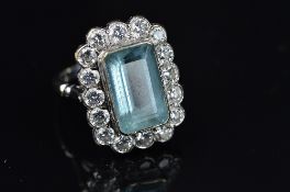 A MODERN LARGE RECTANGULAR AQUAMARINE AND DIAMOND CLUSTER RING, centring on an emerald cut