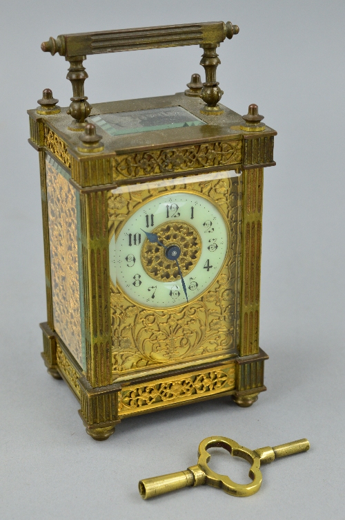 A LATE 19TH CENTURY GILT BRASS CARRIAGE CLOCK, the handle and four columns of square fluted