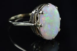 A LATE 20TH CENTURY LARGE WHITE OPAL SINGLE STONE RING, oval cabochon cut opal measuring