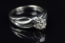 A MODERN PLATINUM DIAMOND RING, centring on a principle modern round brilliant cut diamond,
