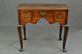 A LATE GEORGE III OAK SIDE TABLE, the rectangular top with rounded corners, the frieze fitted with a