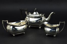A GEORGE V SILVER THREE PIECE TEASET, of rectangular form, teapot with ebonised fitments, all pieces