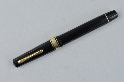 AN OMAS 557-F FOUNTAIN PEN, in black and gold, stamped Omas 557-F, with 1922 along the same facet,