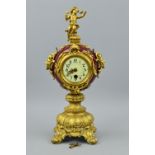 A LATE 19TH/EARLY 20TH CENTURY GILT METAL AND PORCELAIN MANTEL CLOCK, figural surmount on circular