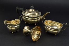 A GEORGE V SILVER THREE PIECE TEASET, of rectangular form, gadrooned rims, teapot with ebonised
