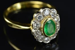 A LATE 20TH CENTURY EMERALD AND DIAMOND OVAL CLUSTER RING, one oval mixed cut emerald rub over set