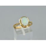 A LATE 20TH CENTURY SINGLE STONE OPAL RING, oval rub over set white opal measuring approximately