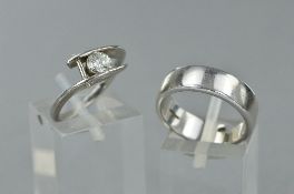 A MODERN SINGLE STONE DIAMOND RING, crossover design, a modern round brilliant cut diamond,