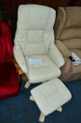 A NEARLY NEW CREAM LEATHER EFFECT ARMCHAIR, and footstool