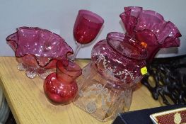 FIVE PIECES OF CRANBERRY COLOURED GLASS, to include shade, footed vase, etc (a/f on single handled