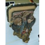 A 19TH CENTURY PLASTER WALL SHELF, with two putti figures scrolls and flower detail to underside
