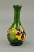 A MOORCROFT POTTERY BUD VASE, 'Hibiscus' pattern on green ground, impressed marks to base