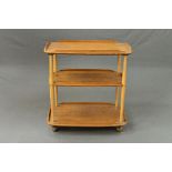 A BLONDE ERCOL THREE TIER TEA TROLLEY, with a gallery top, approximate size width 71cm x depth 45.