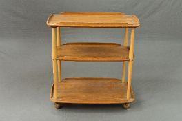 A BLONDE ERCOL THREE TIER TEA TROLLEY, with a gallery top, approximate size width 71cm x depth 45.