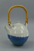 A TEAPOT IN THE STYLE OF DAVID LEACH, the spherical body is decorated with a blue and white glaze