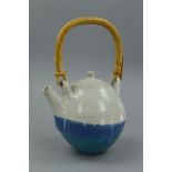 A TEAPOT IN THE STYLE OF DAVID LEACH, the spherical body is decorated with a blue and white glaze