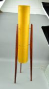 A 1960'S/1970'S TEAK FLOOR STANDING ROCKET LAMP, having cylindrical yellow fibre glass shade,