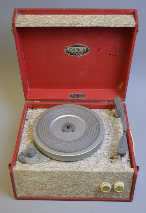 A DANSETTE POPULAR RECORD PLAYER, in red and beige finish, badge to inner lid, approximately 32cm