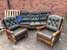 AN OAK FRAMED THREE PIECE LOUNGE SUITE, with removable leather cushions, comprising of a three