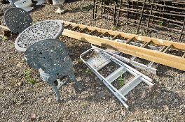 A PLASTIC ROUND GARDEN TABLE, two chairs, a parasol stand, two sets of aluminium step ladders and