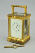 AN EARLY 20TH CENTURY GILT BRASS CARRIAGE CLOCK, the handle, four columns, pediment and foot cast